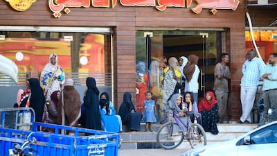 Sudanese people line up outside a bakery in order to buy bread in the capital Khartoum. AFP