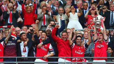 Arsenal captain Thomas Vermaelen, right, lifts the trophy in celebration after the FA Cup final victory over Hull City on Saturday. Clive Mason / Getty Images / May 17, 2014