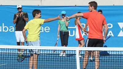 Sufyan Abu Soud, 14, is given a high five by Andy Murray at the Mubadala Community Cup Clinic at Zayed Sports City yesterday. Delores Johnson / The National