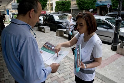 In this picture taken on Saturday, April 28, 2018, Lebanese elections candidate Laury Haytayan, 42, right, speaks to voter in Beirut's Ashrafieh district, Lebanon. Haytayan is running for Parliament on the Kulna Watani list, a coalition of civic activists, businessmen, journalists, and engineers challenging the country's traditional parties for power, in Lebanon's first national elections in 9 years. (AP Photo/Philip Issa)