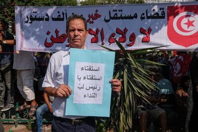 Jamel, 69, holds a sign calling on Kais Saied to hold a referendum on a new constitution, something the president has intimated he may do in the coming months. Photo: Noureddine Ahmed for The National