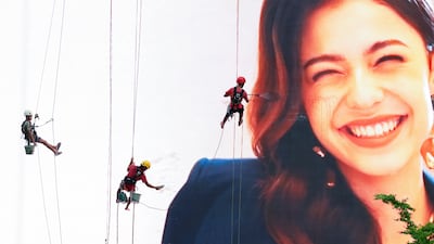 Workers hang on ropes as they clean an advertisement board in Jakarta, Indonesia. Reuters