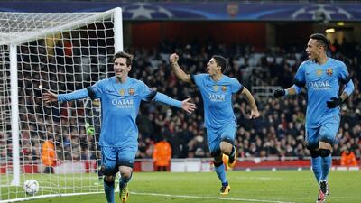 Barcelona players Neymar, right, and Luis Suarez celebrate after Lionel Messi, left, scored the second goal against Arsenal on Tuesday night. Frank Augstein / AP / February 23, 2016