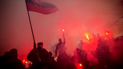 Protesters burn flares as hundreds of football hooligans and far-right voters of Kotleba's LSNS party protest against the government of Igor Matovic and precautionary measures against the spread of the coronavirus in front of the Government Office in Bratislava. AFP