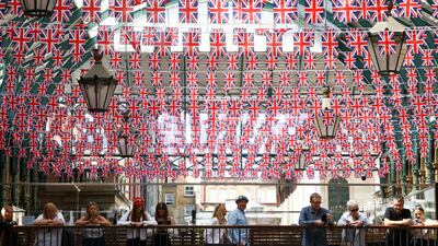 People stand underneath Union Jack flags hanging in Covent Garden, London. Reuters