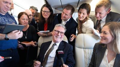 Britain's Prime Minister Keir Starmer talks to journalists as he travels on board a plane to Washington DC. AFP