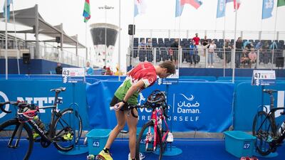 A triathlete makes the transition from swim to bike legs. Reem Mohammed / The National