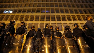 Riot police stand guard during ongoing protests against the Lebanese government, in front of the Central Bank, in Beirut. AP