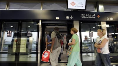 Commuters board the Dubai Tram at Sufouh Station. Jeffrey E Biteng / The National
