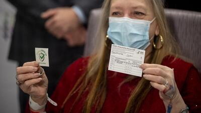 Susan Maxwell-Trumble holds up a vaccination card after receiving a dose of the Johnson & Johnson Covid-19 vaccine in Bay Shore, New York, March 3, 2021. Bloomberg