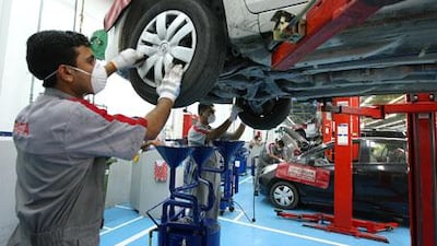 Toyota employees work on cars at a service station in Dubai.