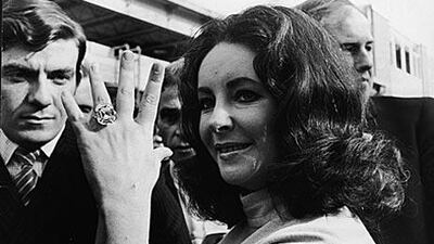 Elizabeth Taylor shows off a 33.19 carat diamond ring given to her in 1968 by her then-husband Richard Burton.