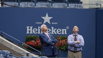Two men look toward the not-yet-completed roof in Arthur Ashe Stadium after play was postponed by rain on Thursday at the US Open. Kathy Willens / AP