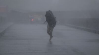 A villager braves strong winds on a road in Bacoor city, Cavite. EPA