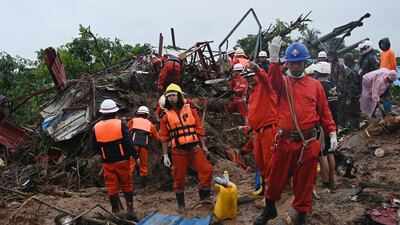 Rescue workers gesture as they search for landslide survivors. AFP