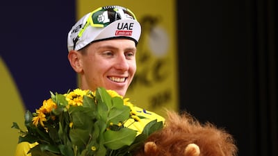 UAE Team Emirates rider Tadej Pogacar celebrates on the podium with the overall leader's yellow jersey after winning the 19th stage of the Tour de France on Friday, July 19, 2024. AFP