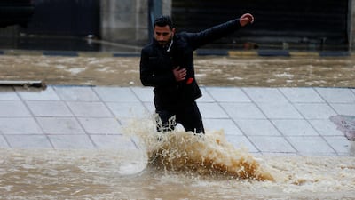 A man crosses a flooded street in Amman. Reuters