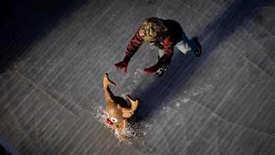 A skater pushes a reindeer-shaped skating aid ahead of them as the winter outdoor ice rink opens on the Museumplein in Amsterdam, the Netherlands. EPA