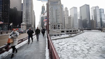 Pedestrians walk along Michigan Avenue above the frozen Chicago River in Chicago. EPA