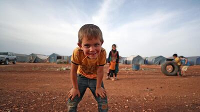 A boy poses for a picture as he plays at a camp for the internally displaced in Maaret Misrin city in Syria's northwestern Idlib province. AFP