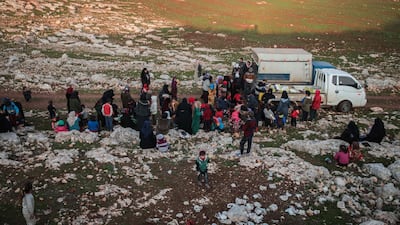 Displaced Syrians from the south of Idlib province receive food aid from a truck in the countryside west of the town of Dana in the northwestern Syrian region. AFP