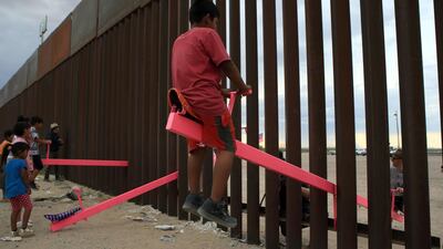 American and Mexican families play with seesaws as part of the Teeter Totter Wall project. AFP