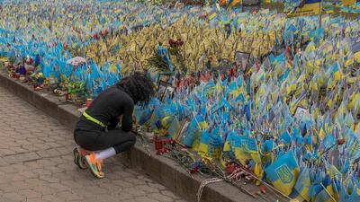 A woman reacts next to flags bearing symbols and colours of Ukraine set to commemorate fallen Ukrainian army soldiers at Independence Square in Kyiv. AFP
