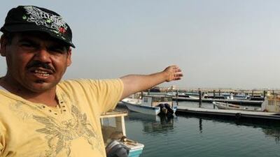 Abdullah Ali Maki, a fisherman, points to a reclamation project at what is left of his Dair village to make way for a housing project.