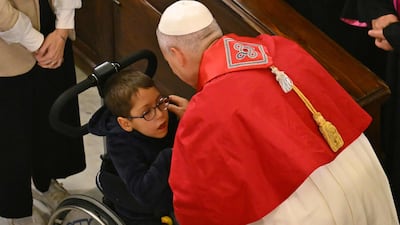 Pope Leo greets a child in a wheelchair at the cathedral. AFP