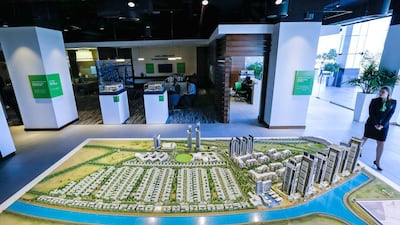 Ajay Rajendran, vice chairman of Sobha Properties, shows a mock-up of the company's Sobha Hartland project. Victor Besa for The National