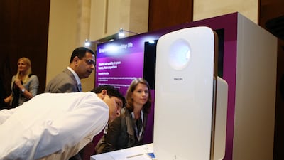 People inspect a Philips smart air purifier. A Hepa filter is expected to remove particles of a certain size with an efficiency above 99.9 per cent. Sarah Dea / The National