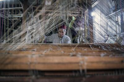 Ouazzani works on a tapestry at his workshop. AFP