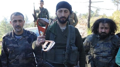 Alpaslan Celik, a deputy commander in a Syrian Turkmen brigade, centre, holding what is believed to be parts of a parachute used by a Russian pilot who ejected from a downed military jet near the northern Syrian village of Yamadi, near the Turkish-Syrian border, Syria on November 24, 2015. Reuters
