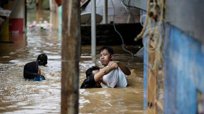 Indonesian residents carry their belongings as they wade through flood water in Jakarta, Indonesia. Mast Irham / EPA