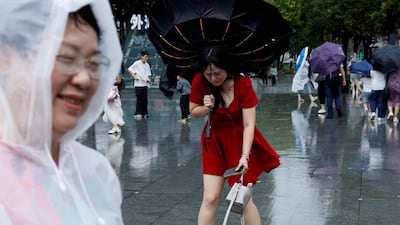 A person holds an inverted umbrella as winds intensify ahead of the arrival of Typhoon Dolphin in Shanghai, China. Reuters