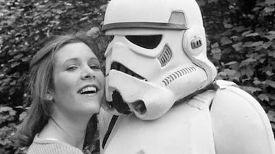 In this May 23, 1980, file photo, actress Carrie Fisher hugs a person dressed as a storm trooper in London while promoting the Star Wars epic The Empire Strikes Back. Dave Caulkin, File / AP photo
