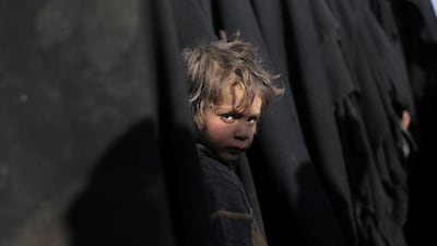 A boy looks at the camera near Baghouz, Syria. Reuters