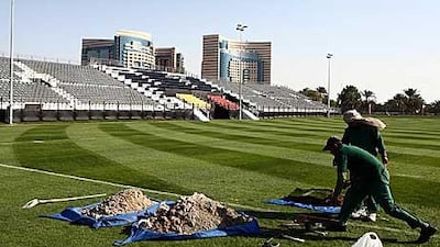 Workers put the finishing touches to the impressive rugby stadium emerging in the grounds of the plush Emirates Palace hotel.
