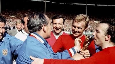 Nobby Stiles kisses the World Cup trophy as Bobby Moore is congratulated by manager Alf Ramsey. PA