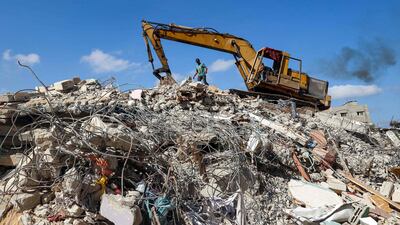 An excavator digs through the remains of a Gaza City building levelled by an Israeli air strike during the May 2021 conflict between Israel and Hamas, on July 13. AFP
