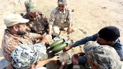 Members of Iraqi Shiite militia Imam Ali Brigades, part of the Shiite Popular Mobilisation Forces, take a break during a live ammunition training exercise in Najaf city, southern Iraq, on August 14, 2017. EPA