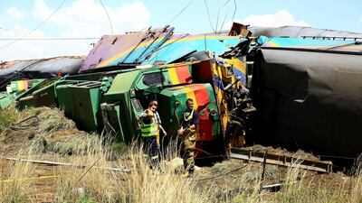 Workers stand next to a wreckage after a train crash near Hennenman. REUTERS/Stringer