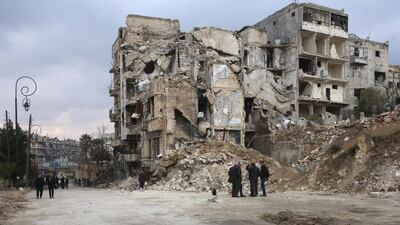 Syrians walk along a destroyed street in the old city of Aleppo. Youssef Karwashan / AFP