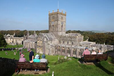 People wait for the arrival of Prince William, and Kate, Princess of Wales, outside St Davids Cathedral, on the first anniversary of Queen Elizabeth's death. AP