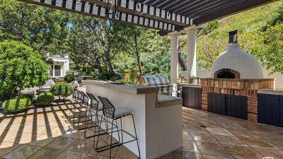 There is an outdoor kitchen with pizza oven next to the guest house