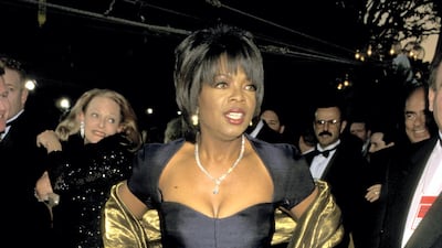Oprah Winfrey wears a navy gown with a gold shawl to attend the 68th Annual Academy Awards on March 25, 1996. Getty Images