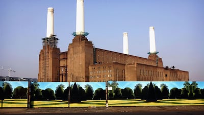 Battersea Power Station stands behind boards painted with a landscape in 2005. Getty Images
