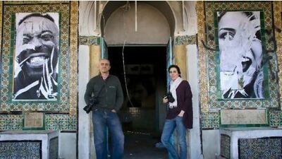 Framed at the police station: the photographers Aziz Tnani, left, and Rania Dourai between two portraits their group pasted to the walls of the former police station in the Tunis suburb of La Goulette.