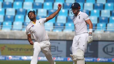 Pakistan's Wahab Riaz, left, delivers a ball as England's Jonny Bairstow looks on during the Day 3 of the second Test match between Pakistan and England in Dubai on October 24, 2015. AFP PHOTO / MARWAN NAAMANI