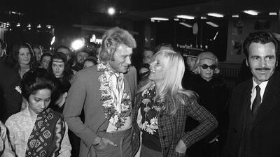 (FILES) In this file photo taken on February 1, 1969 French singer Johnny Hallyday (L) and then his wife singer Sylvie Vartan attend the preview of the film "Krakatoa, a l'est de Java" directed by Bernard Kowalski (not pictured) with Austrian actor Maximilian Schell (R) at a Parisian cinema. France's best-known rock star Johnny Hallyday has died aged 74 after a battle with lung cancer, his wife Laeticia told AFP on December 6, 2017. / AFP PHOTO / -